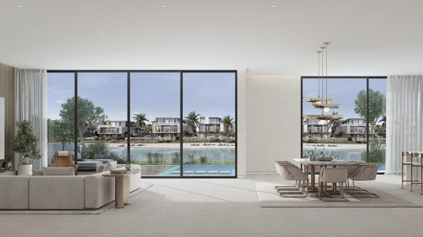 Intérieur de salon moderne avec de grandes fenêtres en verre offrant une vue sur un lac tranquille et des villas de luxe à Dubaï. Présente un mobilier minimaliste, des tons neutres et une esthétique design élégante.
