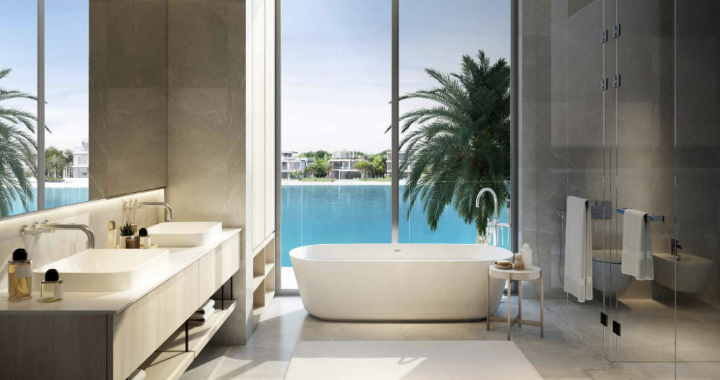 Une salle de bains luxueuse avec une baignoire autoportante, deux lavabos et une douche, donnant sur une piscine extérieure tranquille entourée de palmiers dans un appartement de Dubaï. De grandes baies vitrées offrent une vue sur un