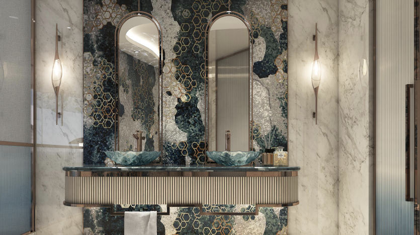 Salle de bains luxueuse dans un appartement de Dubaï comprenant une double vasque avec des lavabos bleu sarcelle uniques, des miroirs ornés et un mur décoratif en mosaïque dans les tons bleu et or. Un éclairage chaleureux et des détails en marbre améliorent l&#039;opération