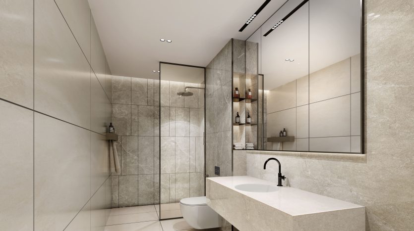 Intérieur de salle de bains moderne comprenant un grand miroir, un comptoir en pierre avec lavabo, un espace douche entouré de verre et des murs carrelés beiges éclairés par des plafonniers dans une luxueuse villa de Dubaï.