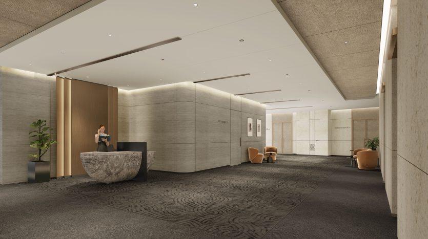 Un hall de bureau moderne avec des murs beiges, une moquette grise à motifs, des accents en bois et un mobilier contemporain géré par une importante agence immobilière de Dubaï. Une réceptionniste se tient devant un bureau incurvé,