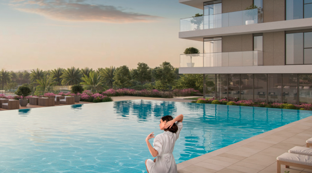 Une femme vêtue d&#039;une robe blanche est assise au bord d&#039;une piscine luxueuse au coucher du soleil, regardant un paysage serein avec une verdure luxuriante et des fleurs roses. Un bâtiment architectural moderne avec des balcons en arrière-plan, caractéristique