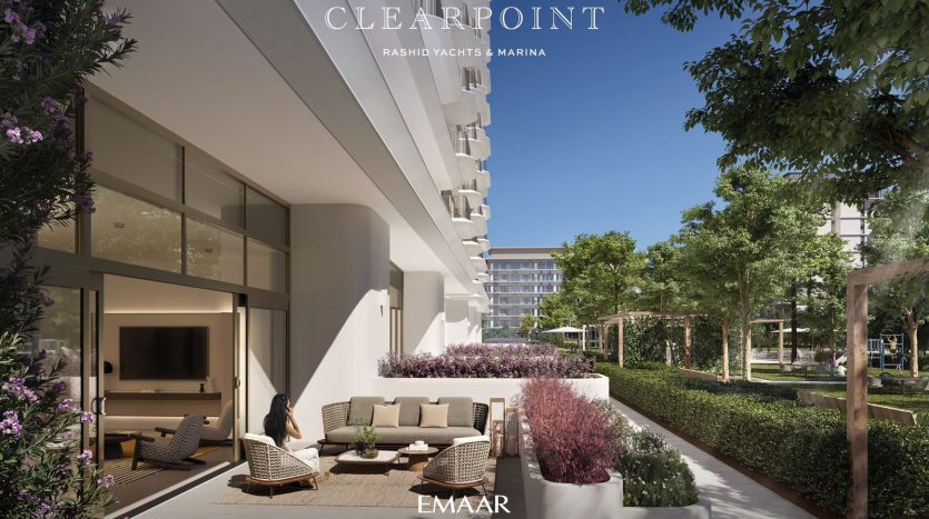 Un luxueux balcon doté de sièges moelleux donne sur un jardin paysager et une marina, faisant partie du complexe résidentiel Clearpoint à Dubaï, mis en valeur par des gratte-ciel et une verdure luxuriante.