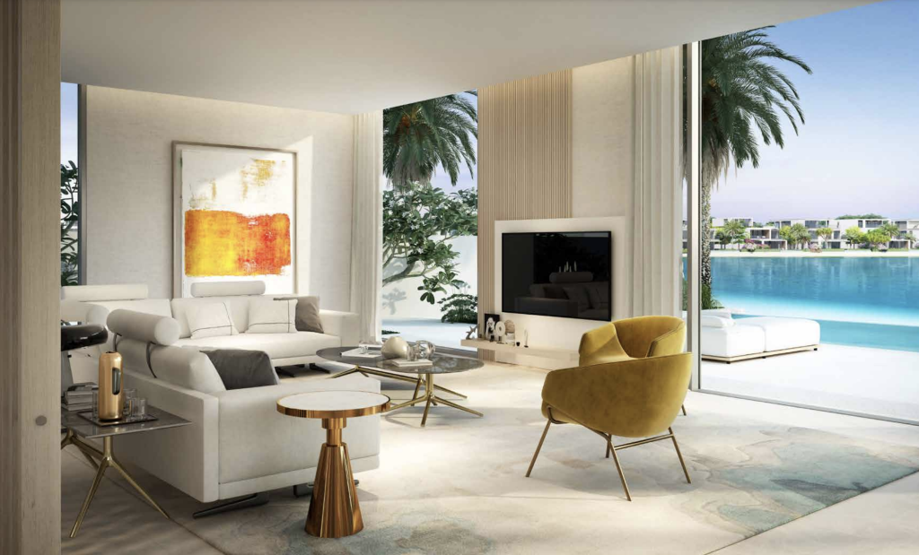 Un salon luxueux avec un canapé blanc, un fauteuil jaune moutarde et une décoration moderne dans un appartement de Dubaï, donnant à travers des portes coulissantes en verre sur un lac bleu calme.