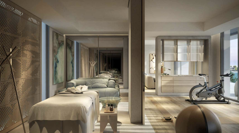 Un intérieur d'appartement de luxe moderne à Dubaï avec un agencement ouvert reliant une chambre, un salon et un espace de sport, mettant en valeur un mobilier contemporain et une lumière naturelle.