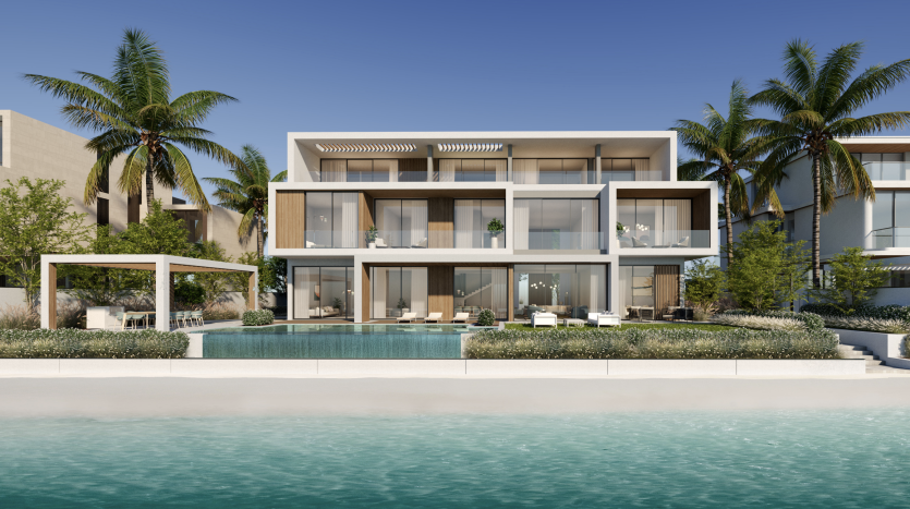 Villa moderne en bord de mer à Dubaï avec de grandes fenêtres en verre, plusieurs balcons et une piscine entourée de palmiers sous un ciel bleu clair.