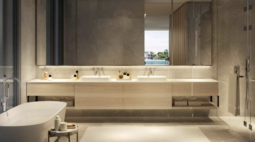 Une salle de bains luxueuse dans un appartement de Dubaï comprenant une longue vasque en bois avec deux lavabos, de grands miroirs, une baignoire îlot et une vue sur un balcon extérieur. La pièce est éclairée par une lumière douce,