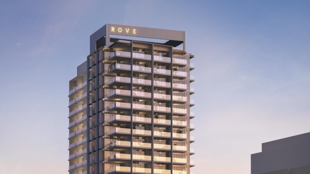 Un immeuble moderne de grande hauteur surmonté du mot « rove », doté de plusieurs balcons et d&#039;un ciel clair en arrière-plan au crépuscule, est représenté par une importante agence immobilière de Dubaï.