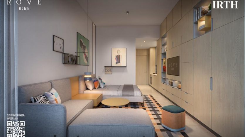 Un intérieur d&#039;appartement moderne à Dubaï comprenant un canapé bleu, un tapis à motifs, des armoires en bois clair et plusieurs œuvres d&#039;art murales. Un éclairage doux émane de luminaires cachés, mettant en valeur une vie confortable et élégante