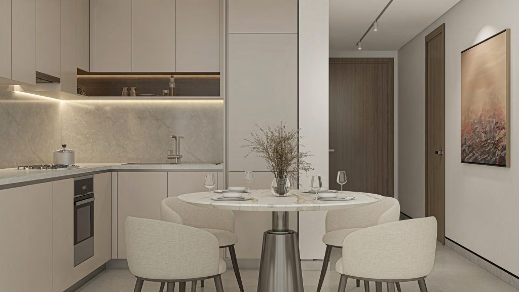 Cuisine moderne dans un appartement de Dubaï avec une salle à manger minimaliste comprenant une table ronde pour quatre personnes, des armoires en bois clair, des appareils intégrés et des murs en marbre aux tons doux. Un tableau est accroché à côté du bois