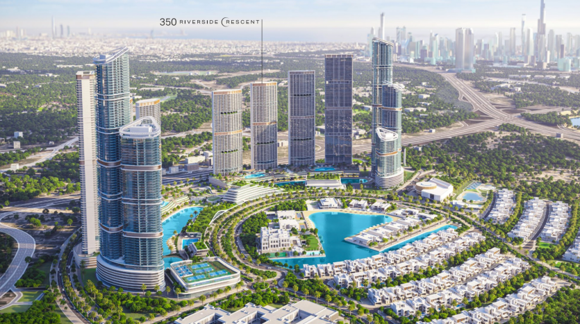 Vue aérienne d&#039;un développement urbain moderne comprenant des immeubles de grande hauteur, un grand lac artificiel, des espaces verts luxuriants et des zones résidentielles de villas de Dubaï, avec un horizon urbain en arrière-plan.
