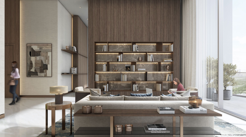 Un salon spacieux dans une villa à Dubaï avec de grandes fenêtres, des meubles modernes et une étagère en bois remplie de livres et de décorations. Deux personnes se détendent dans la pièce, l&#039;une lisant près de la fenêtre et