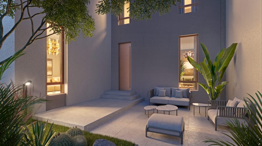 Patio extérieur confortable d&#039;une maison moderne de Dubaï au crépuscule, doté d&#039;un éclairage élégant, de sièges confortables, de plantes luxuriantes et d&#039;une ambiance sereine.