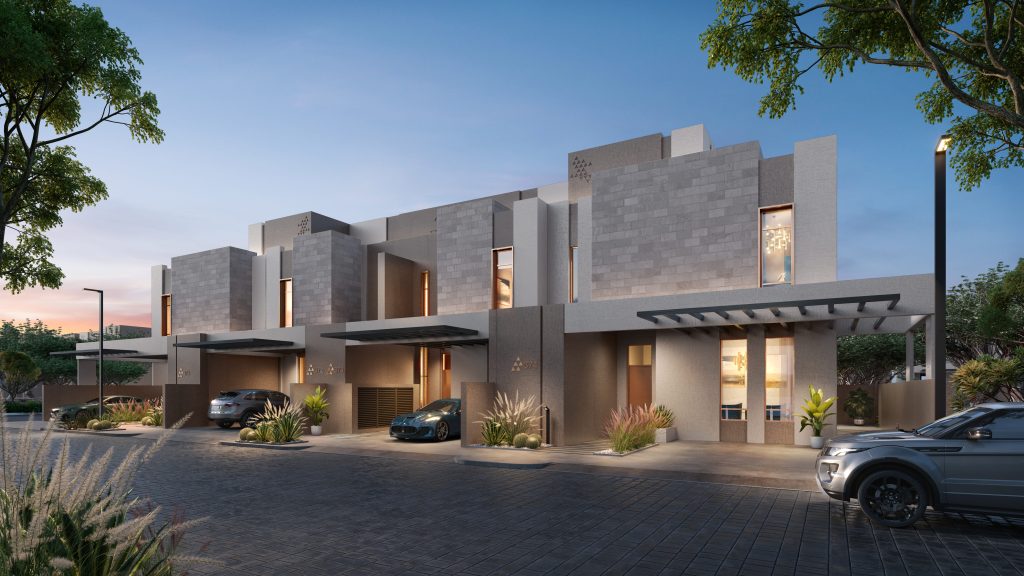 Villas résidentielles modernes à Dubaï avec des intérieurs éclairés et un éclairage extérieur au crépuscule, avec des voitures garées, des jardins bien entretenus et un ciel dégagé.