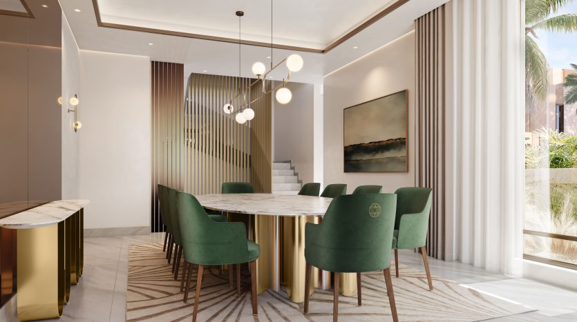 Salle à manger moderne dans une villa de Dubaï comprenant une table en marbre, des chaises en velours vert, des touches dorées et un grand tableau abstrait. La lumière naturelle inonde l’espace, mettant en valeur le décor élégant et luxueux.