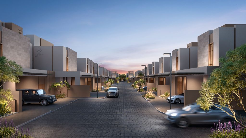 Rue résidentielle moderne au crépuscule avec des maisons symétriques, des voitures dans les allées et un ciel rose et bleu vif. Les arbres décoratifs et l&#039;aménagement paysager rehaussent l&#039;atmosphère tranquille de la banlieue, qui rappelle un quartier chic de Dubaï.