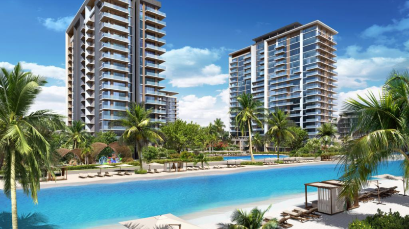 Rendu artistique d&#039;un complexe de luxe en bord de mer avec deux immeubles de grande hauteur entourés de palmiers, une grande piscine et une plage avec des chaises longues sous des parasols, mettant en valeur le premier immobilier de Dubaï.