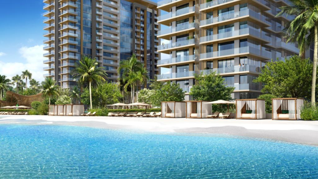Un immeuble d&#039;appartements moderne et luxueux avec de larges balcons donnant sur une grande piscine sereine entourée de palmiers et de cabanes privées dans un cadre tropical à Dubaï.