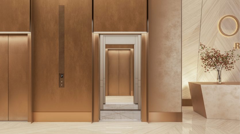 Un hall d&#039;entrée d&#039;hôtel moderne avec des portes d&#039;ascenseur élégantes et dorées s&#039;ouvre, révélant un intérieur en marbre qui ressemble au design luxueux que l&#039;on retrouve souvent dans une Villa Dubaï, à côté d&#039;un élégant bureau de réception avec un arbre en pot.