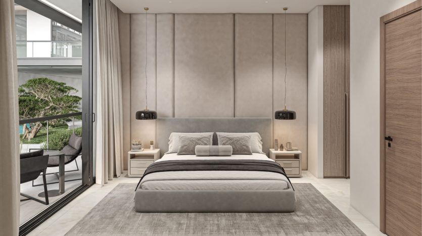 Une chambre moderne dans une villa à Dubaï comprenant un grand lit gris avec des draps assortis, flanqué de tables de nuit et de suspensions. De grandes fenêtres donnent sur un balcon planté d&#039;arbres verts. Tons neutres