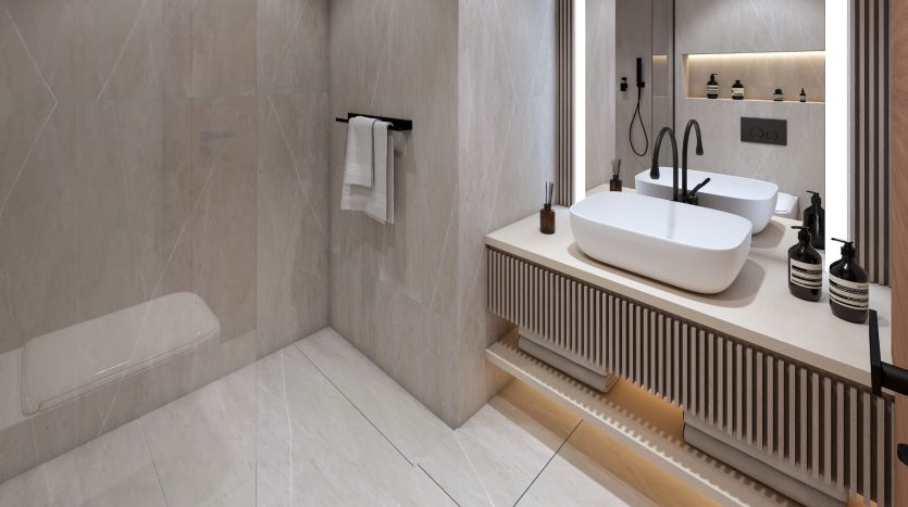 Intérieur de salle de bains moderne comprenant un lavabo rectangulaire sur une vanité en bois, un grand miroir, des luminaires de style minimaliste et une douche à l&#039;italienne avec cloison en verre dans une villa de Dubaï.