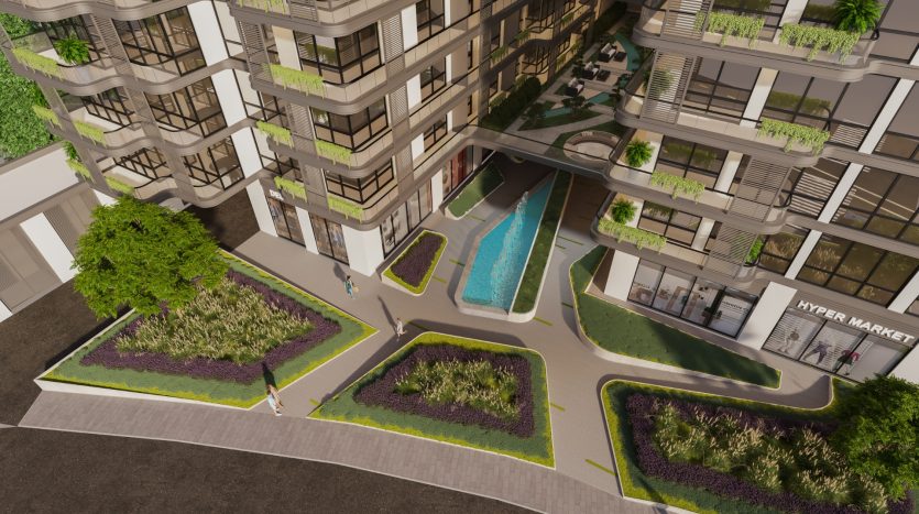 Vue aérienne d&#039;un complexe d&#039;appartements moderne doté d&#039;une piscine centrale, de jardins luxuriants et d&#039;un hypermarché, entouré d&#039;immeubles de plusieurs étages avec balcons à Dubaï.