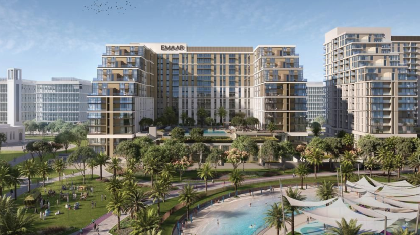 Vue aérienne d&#039;un développement urbain moderne comprenant des immeubles de grande hauteur portant le logo « emaar », entourés d&#039;une verdure luxuriante, de palmiers et de personnes profitant d&#039;une journée ensoleillée avec une grande piscine