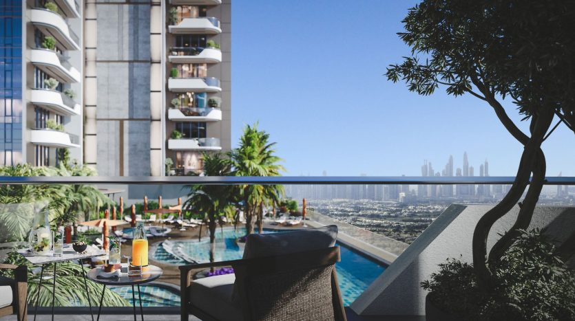 Balcon de luxe avec vue sur les toits de la ville et un espace piscine avec chaises longues et tables dressées avec boissons, à côté d'une verdure luxuriante et d'immeubles de grande hauteur modernes, parfait pour investir à Dubaï.