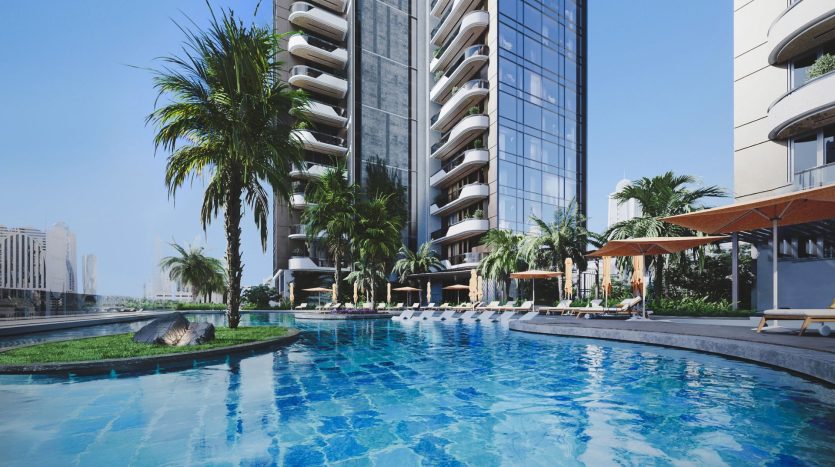 Un espace luxueux au bord de la piscine aux eaux cristallines, entouré de palmiers et d&#039;appartements modernes de grande hauteur à Dubaï sous un ciel bleu clair.