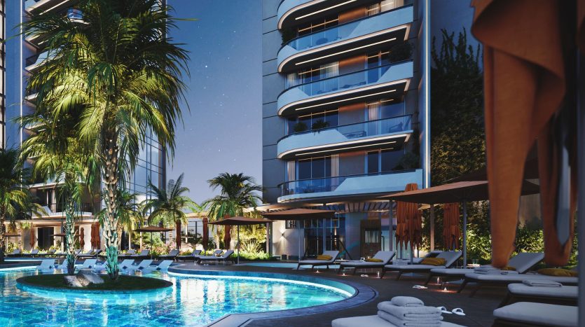 Une piscine d'hôtel luxueuse au crépuscule à Dubaï, avec de l'eau illuminée, entourée de palmiers, de chaises longues et d'immeubles modernes de grande hauteur.