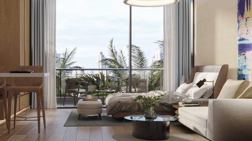 Un intérieur d&#039;appartement moderne avec un lit et un canapé, ouvrant sur un balcon avec des plantes donnant sur les toits de la ville. La pièce est bien éclairée par la lumière naturelle du soleil et présente un mobilier et une décoration contemporains à Dubaï.