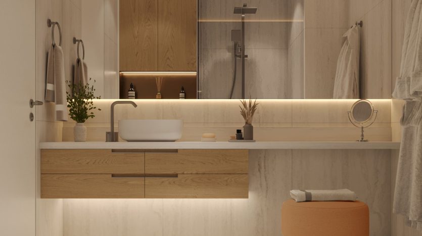 Une salle de bains de villa moderne à Dubaï avec des armoires en bois et un lavabo blanc, doté de grands miroirs, d'un éclairage subtil et de plantes décoratives, créant une ambiance chaleureuse et sereine.