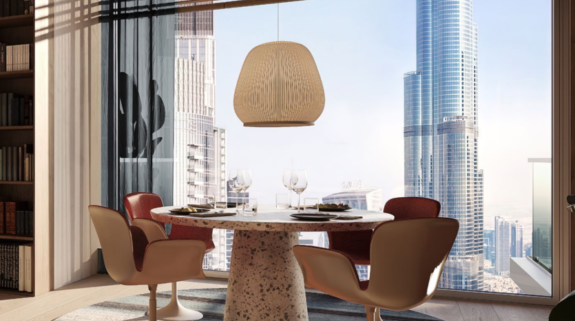 Salle à manger moderne dans un appartement de Dubaï avec une table ronde pour deux, des chaises rouges élégantes, une grande suspension au-dessus, entourée d&#039;étagères, donnant sur un paysage urbain du sol au plafond