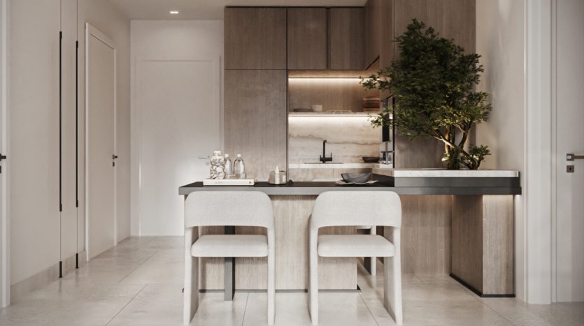Intérieur de cuisine moderne dans une villa de Dubaï avec des armoires en bois élégantes, un dosseret en marbre et un îlot central avec deux tabourets de bar. Une plante décorative ajoute une touche de verdure.