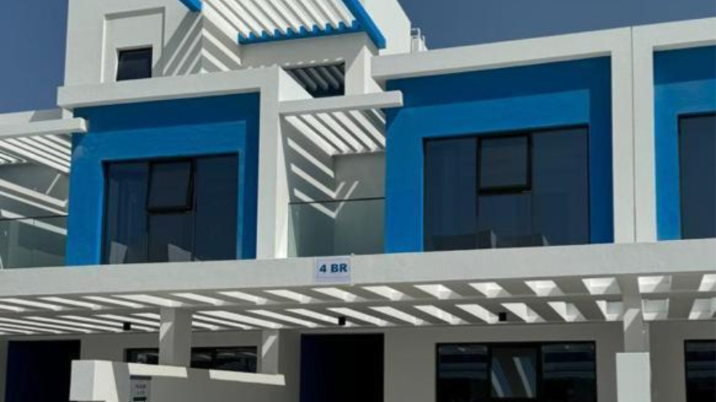 Façade architecturale moderne présentant un bâtiment aux lignes nettes, aux accents bleus audacieux et aux couleurs gris et blanc, affichant une structure d&#039;ombre à motifs dans un projet d&#039;Investissement Dubaï.