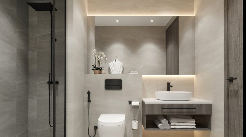 Intérieur de salle de bains moderne comprenant une douche à l&#039;italienne, un lavabo mural, des armoires, des carreaux gris élégants et un éclairage doux. La décoration comprend des serviettes et une petite plante en pot, idéale pour une villa en