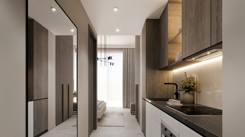 Intérieur de cuisine moderne avec armoires en bois élégantes, comptoirs blancs et appareils électroménagers intégrés dans un luxueux appartement de Dubaï. Des plafonniers à intensité variable éclairent l&#039;espace menant à une pièce attenante avec une suspension visible