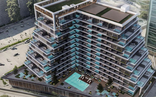 Vue aérienne d&#039;un immeuble d&#039;appartements moderne à plusieurs niveaux à Dubaï avec des balcons en verre, une grande piscine et des terrasses paysagées, entourées d&#039;un quadrillage de rues avec des voitures.
