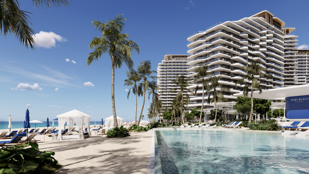 Ein luxuriöser Komplex am Meer mit einem großen Swimmingpool, umgeben von Palmen und modernen Hochhäusern unter einem hellblauen Himmel - perfekt für Investitionen in Dubai.