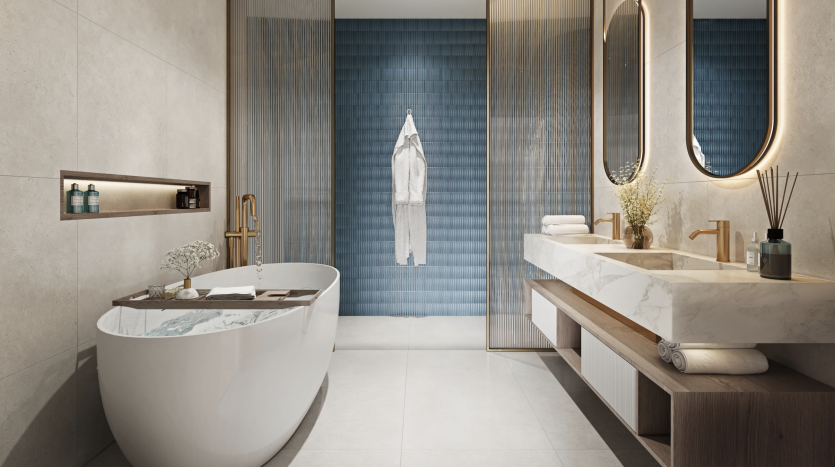 Salle de bains moderne et luxueuse dans une villa de Dubaï comprenant une baignoire autoportante, une double vasque avec des comptoirs en marbre, des miroirs ronds et un mur vertical d&#039;accent en carrelage bleu. Un éclairage chaleureux et des lignes épurées créent une ambiance sereine