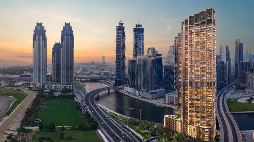 Une vue panoramique d&#039;un paysage urbain moderne au crépuscule avec des gratte-ciel imposants le long d&#039;une rivière sinueuse et des parcs verdoyants à Dubaï, éclairés par la lueur chaleureuse du soleil couchant.