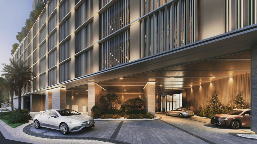 Entrée d&#039;hôtel moderne avec une conception architecturale sophistiquée, comprenant une allée couverte et des plantes luxuriantes, éclairée par un éclairage chaleureux avec deux voitures de luxe garées devant, incarnant une opportunité d&#039;investissement d&#039;élite à Dubaï.