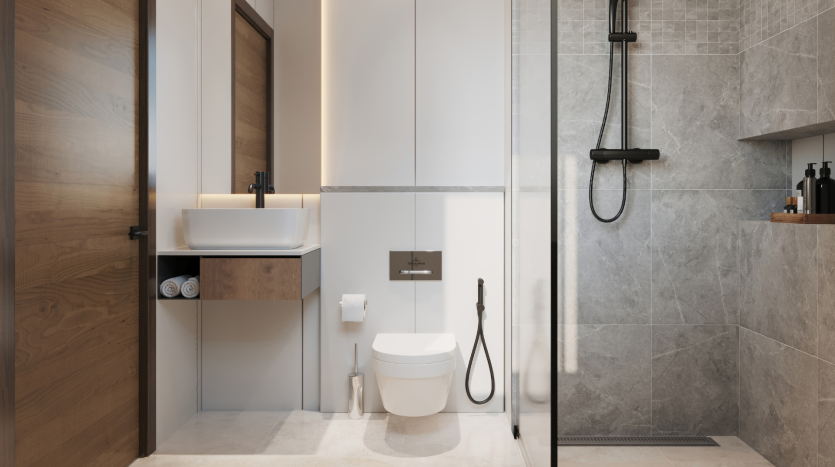 Salle de bain moderne comprenant des toilettes suspendues, un lavabo avec vasque, des miroirs et une douche à l'italienne avec porte vitrée, dans une palette de couleurs neutres avec des carreaux gris texturés. Idéal pour un investissement immobilier
