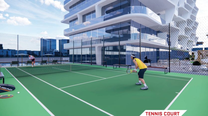 Deux personnes jouant au tennis sur un court vert situé sur le toit d&#039;un appartement à Dubaï avec un bâtiment blanc futuriste en arrière-plan et un ciel bleu avec des nuages.