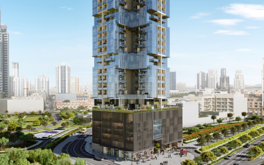 Un immeuble moderne de grande hauteur doté de vastes façades vitrées et de balcons verts se dresse en bonne place dans un cadre urbain, entouré de parcs luxuriants et d'autres gratte-ciel sous un ciel dégagé à Dubaï.