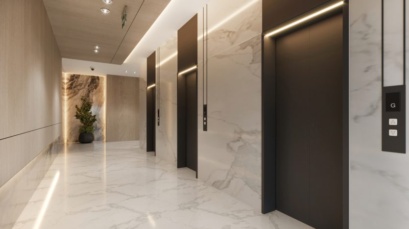Hall d&#039;entrée d&#039;un bâtiment moderne avec sols en marbre poli, deux ascenseurs avec panneaux lumineux et une série de portes sur la droite. Une plante en pot ajoute une touche de verdure, idéale pour investir Dubaï
