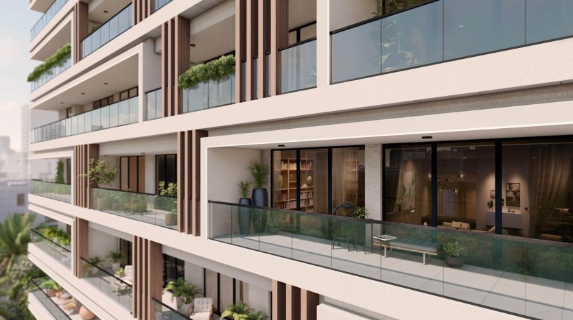 Façade d&#039;un immeuble d&#039;appartements moderne à Dubaï comprenant des balcons avec des balustrades en verre et des plantes vertes, mettant en valeur les intérieurs visibles à travers de grandes fenêtres.