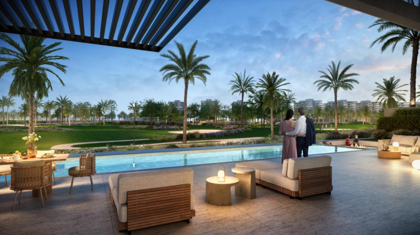 Un couple se tient sous un pavillon ombragé surplombant une piscine luxueuse et des jardins luxuriants au crépuscule, avec des sièges extérieurs confortables à proximité, mettant en valeur les normes exceptionnelles de l&#039;appartement Dubaï.