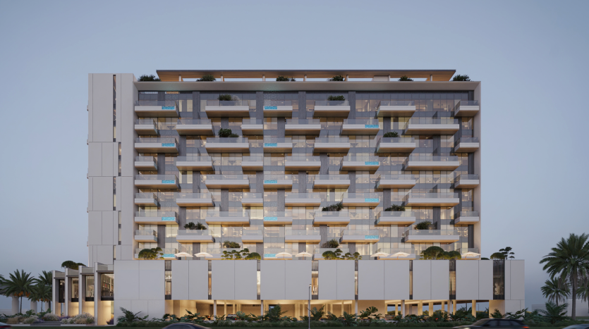 Immeuble d'appartements moderne à plusieurs étages au crépuscule, doté de balcons spacieux, de grandes fenêtres en verre, de plantes à chaque étage et entouré de palmiers luxuriants, disponible via une agence immobilière de premier plan à Dubaï.