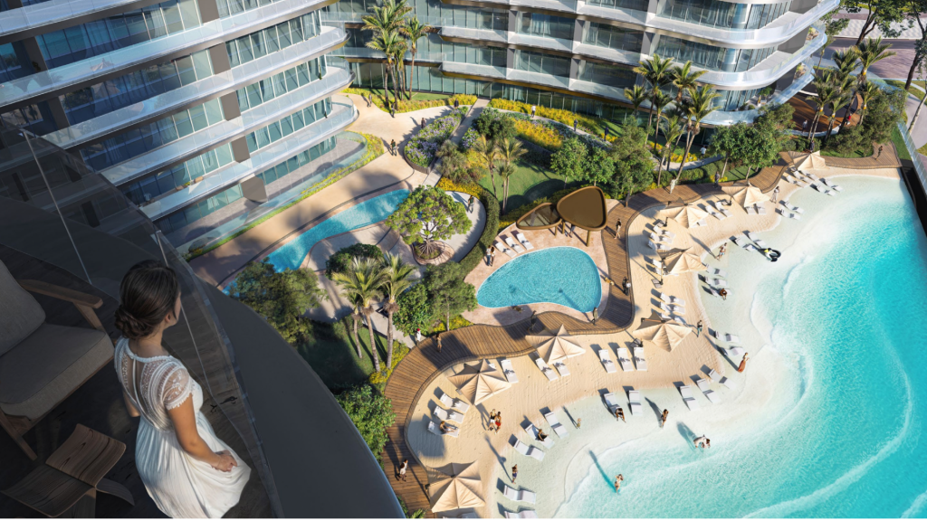 Une femme vêtue d’une robe blanche se tient sur un haut balcon d’une luxueuse villa de Dubaï, surplombant des piscines sinueuses, des jardins luxuriants et des chaises longues sous un soleil éclatant.